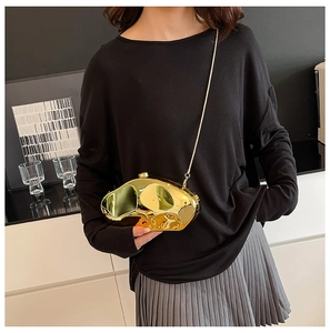 Dettaglio di una pochette dorata a specchio dalla forma liquida con tracolla