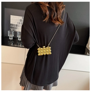Detail van een gouden acryl mini box tas met 3D-parelstructuur en metalen ketting
