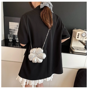 Silver flower evening clutch bag with chain strap styled on a black blazer jacket