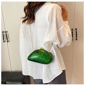 Detail of green marble acrylic evening clutch with gold chain and double ball clasp