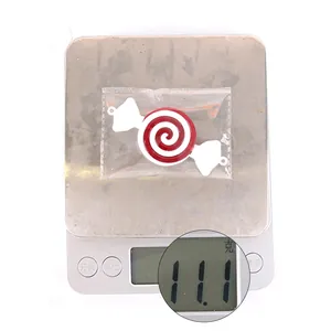 Detail showing red and white spiral candy ornament weight on a digital scale