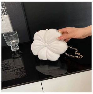Detailed macro view of white 3D flower evening bag with elegant golden chain strap