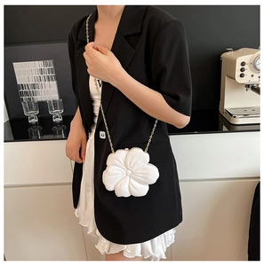 Detailed view of 3D white flower evening bag with a delicate gold chain strap
