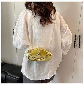 Dettaglio elegante pochette da sera dorata con manico in perle e finitura in metallo lucido