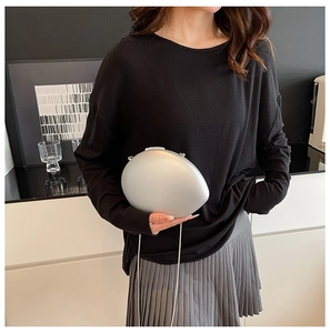 Chic silver pebble clutch bag with metallic matte finish and chain strap on a model
