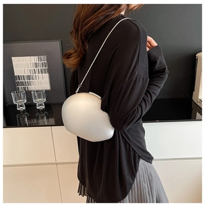 Close-up of minimalist silver pebble-shaped acrylic shell crossbody bag with metal chain