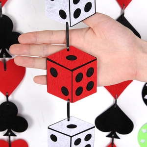 Detail showing 3D felt dice and poker suit ornaments held in hand for scale