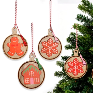 Detailed view of four wooden Christmas ornaments with gingerbread man and snowflake patterns