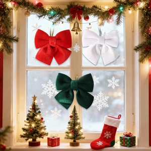 Close-up of three velvet Christmas bows in red, white and green on a festive window sill