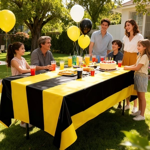 Outdoor party setting with yellow and black striped disposable waterproof tablecloth