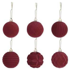 Dettaglio di sei palline di Natale floccate rosso scuro con diverse texture geometriche