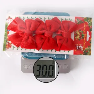 Detailed view of 4-pack red velvet Christmas bows on a scale showing 30.0g weight