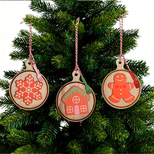 Christmas wooden round charms with snowflake and gingerbread man hanging on a tree