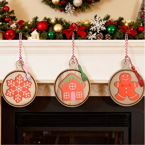 Three round wooden Christmas ornaments featuring snowflake, gingerbread house and man