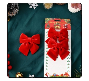 Close-up of red velvet Christmas bows on festive Santa packaging with green background