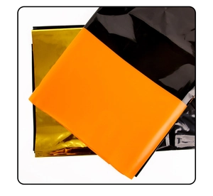 Macro shot of folded PET material in orange and black gold metallic stripes for party decor