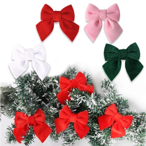 Close-up of colorful velvet Christmas bows on snowy pine branches for DIY decor