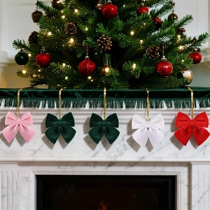 Close-up of colorful velvet bow ornaments hanging on a festive marble fireplace