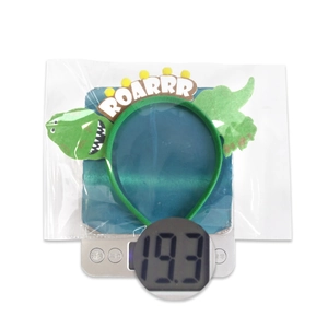 Macro shot of 19.3g green dinosaur headband with ROARRR text on a digital weight scale