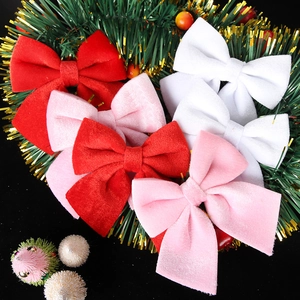 Set of six red, pink, and white velvet Christmas bows on a green decorative wreath