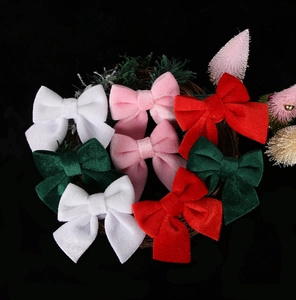 Close-up of velvet Christmas bows in multiple colors on a rustic wreath decoration