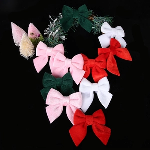 Flat lay of colorful velvet bows and snow-flocked wreath for Christmas tree decoration