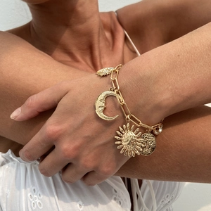 Golden sun and moon face pendant bracelet with textured link chain and sparkling rhinestones