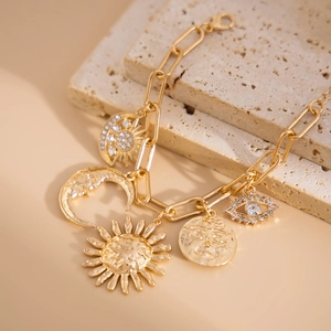 Close-up of gold sun and moon charms on a bohemian link bracelet with crystal details