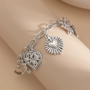 Macro view of vintage silver chain bracelet with heart and sun charm details
