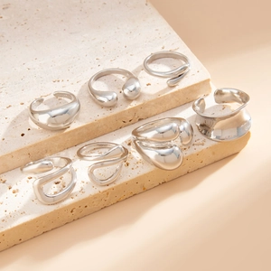 Detailed view of silver organic rings set on minimalist beige travertine stone stairs