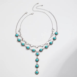 Detail of silver heart choker and Y-shaped necklace with embossed turquoise pendants