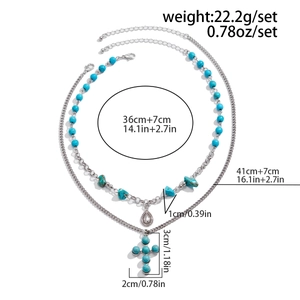 Detailed view of layered necklace with turquoise cross pendant and beaded chain set