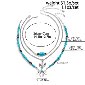 Close-up of bohemian layered silver necklace with turquoise beads and cactus pendant details