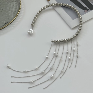 Detailansicht der silbernen Perlenkette mit Metallquasten und Perlen auf weißem Hintergrund