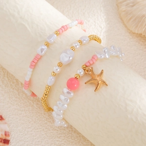 Close-up of three-piece beaded bracelet set with starfish charm and ocean style pearls
