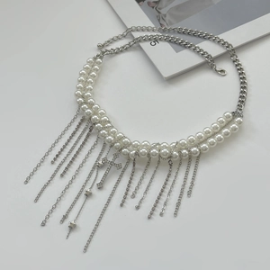Detail einer Gothic-Perlenkette mit Lagen-Quasten und Kreuzanhänger auf weißem Grund