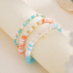 Detail of three colorful ocean-style beaded bracelets featuring a white starfish pendant