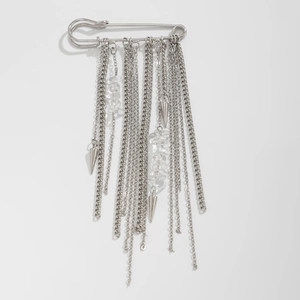 Detail of silver safety pin brooch with long metallic tassels and crystal stone charms