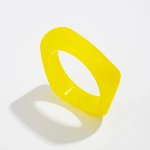 Close-up of a wide yellow resin geometric ring with a modern minimalist design