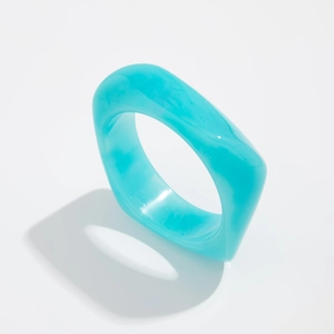 Macro detail of a chunky square resin ring featuring green marble texture and smooth finish