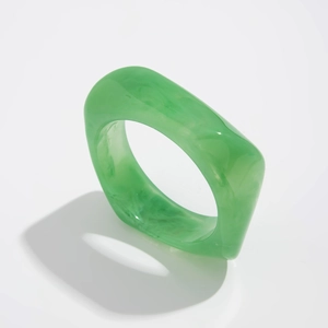 Detail of green resin ring with marble pattern and modern square geometric style
