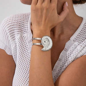 Nahaufnahme des silbernen Armreifs mit einem großen Spiral-Seemuschel-Design