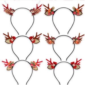 Detail view of 6 Christmas reindeer headbands with sequins, bows and festive ornaments