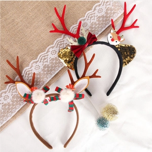 Detail of Christmas reindeer headbands with red antlers, sequins and plaid bow accents