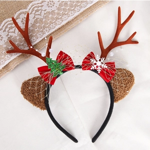 Detailed view of red bow and green sequin tree on plush Christmas reindeer antler headband