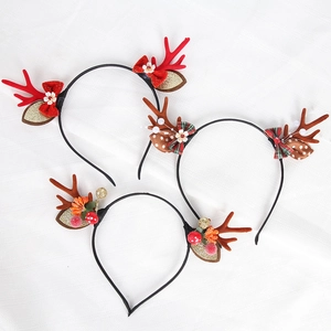 Detailed view of three festive Christmas reindeer antler headbands with ribbons and berries