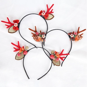 Detail of Christmas reindeer headbands with red bows, berries and glitter leaves