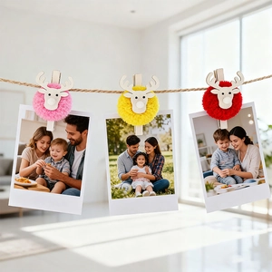 Detail of plush reindeer photo clips in pink, yellow, and red with wooden antlers