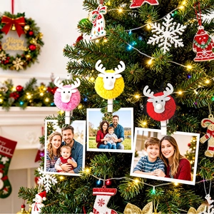 Christmas reindeer wooden photo clips with colorful pom poms on decorated holiday tree