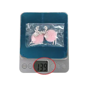 Detail showing weight measurement of plush deer antler clips at 13.9g on a scale